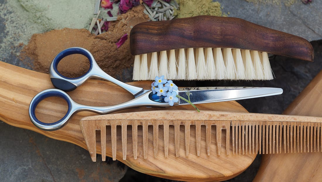 Friseurschere, Holzkamm und Bürste mit Vergissmeinnicht